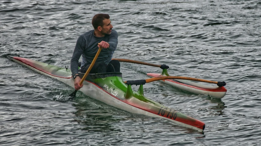 a man holding an oar and standing on the water