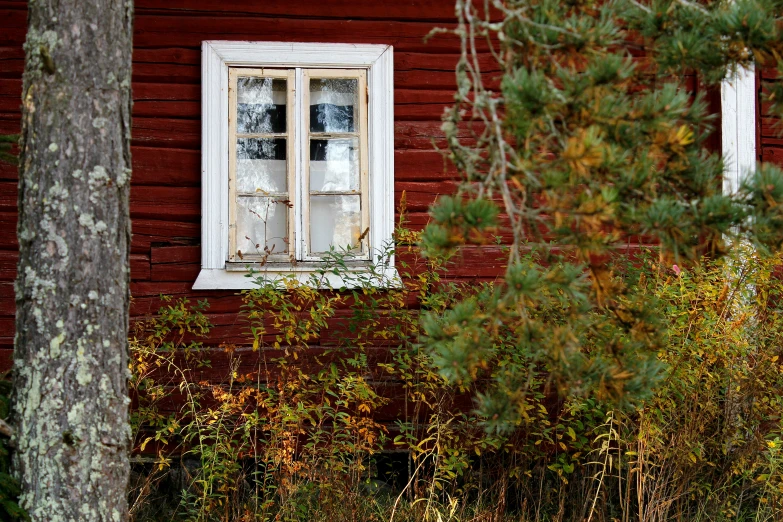 a window on an old red painted house