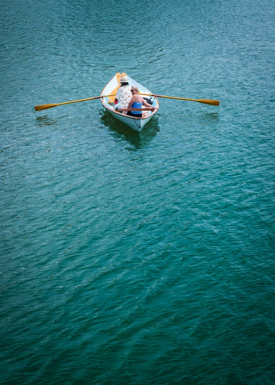 there is a man rowing his boat in the ocean