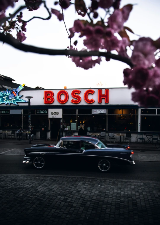the classic car is parked outside a restaurant
