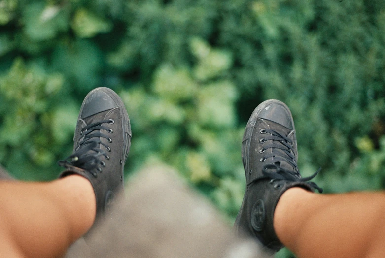 a persons feet wearing sneakers and looking over their shoulders
