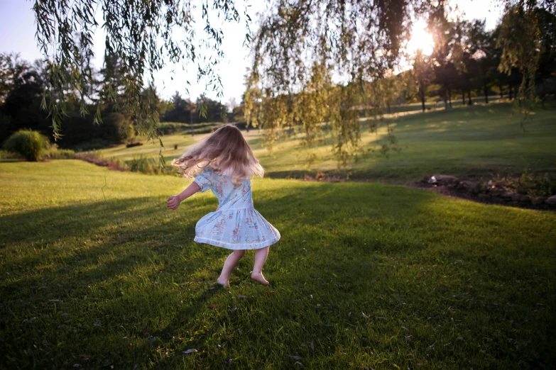 a little girl is running on the grass