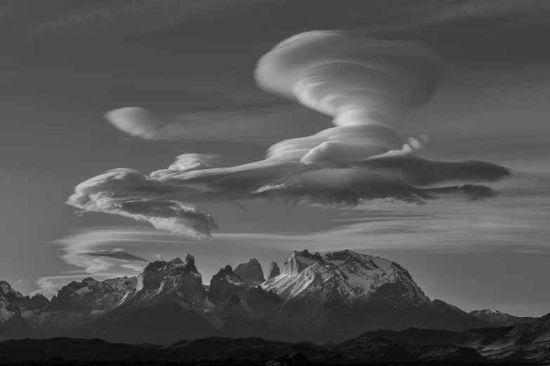 a black and white po of clouds over mountains