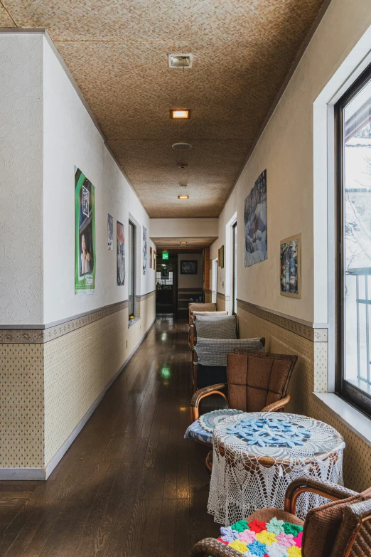 a long hallway with wicker chairs and pictures on the wall