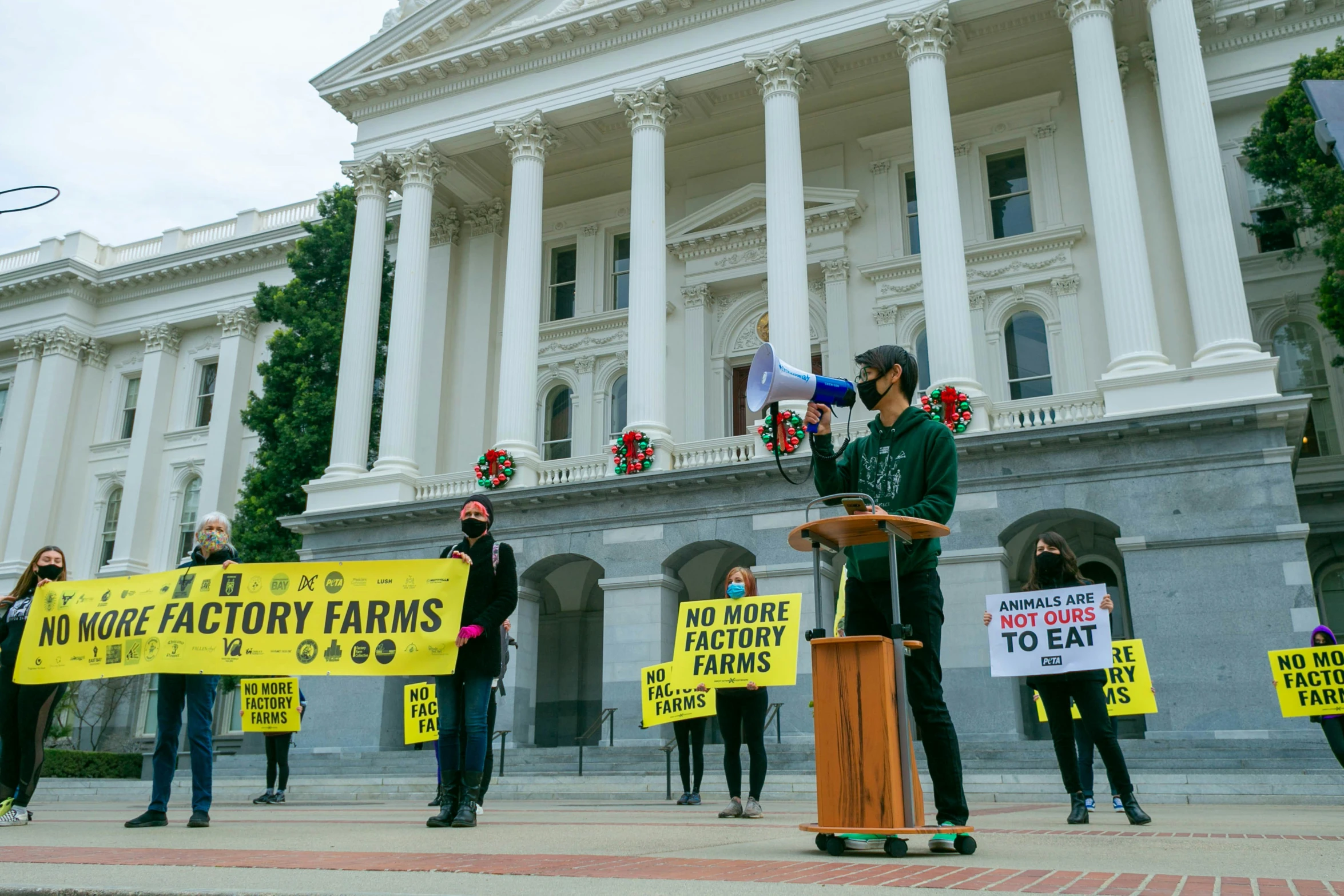 protestors on a city street with signs and a microphone