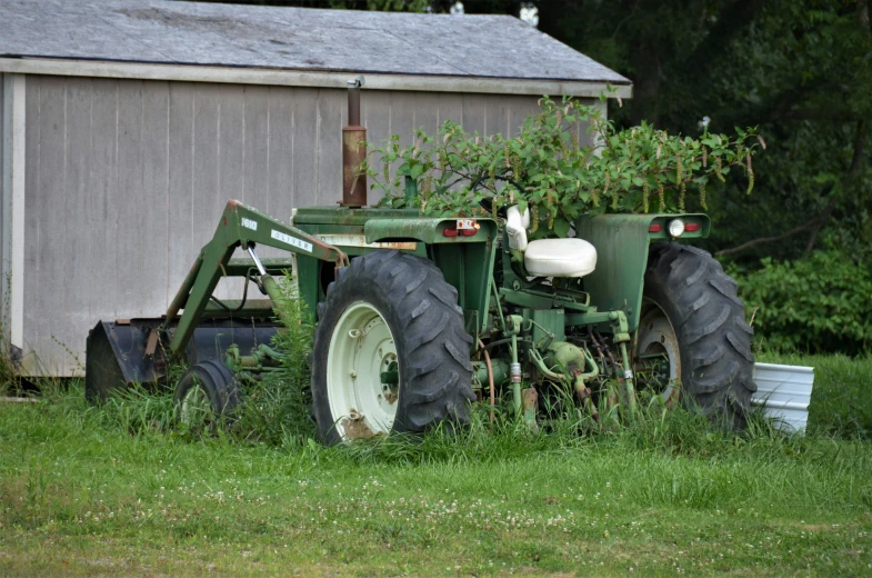 a big green tractor sitting on top of a green field