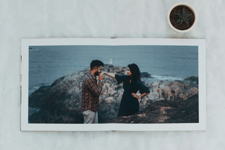 two people on a cliff pointing towards each other