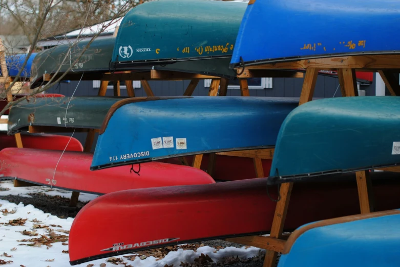 several colorful canoes are lined up beside each other