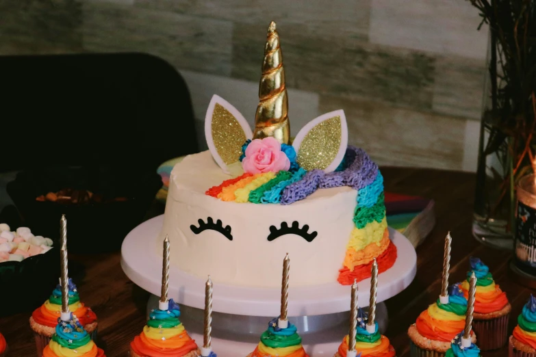 there are many cupcakes decorated in the colors of the rainbow and unicorn