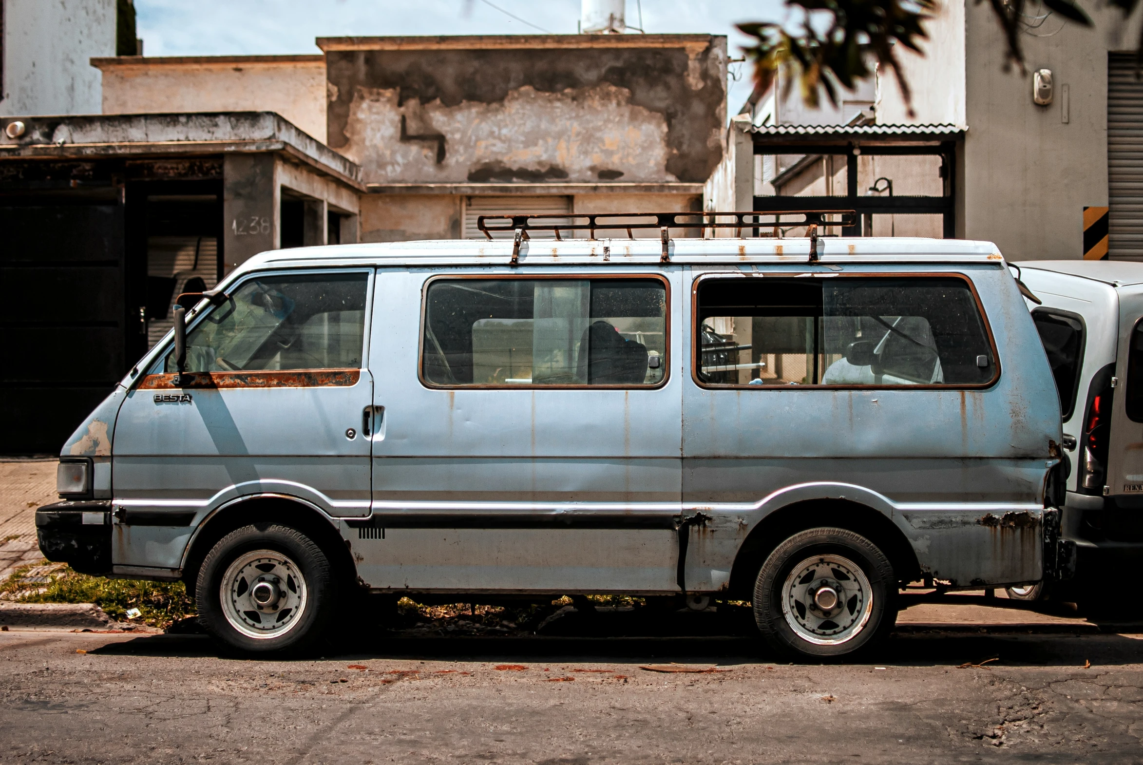 a small blue van is parked in front of an old building