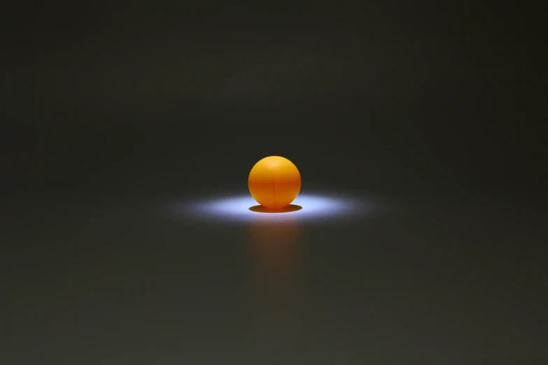 an orange standing in the dark with its head glowing