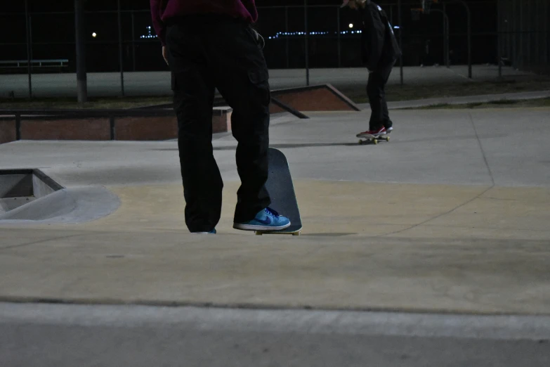 a person standing next to a skateboard near another skate board