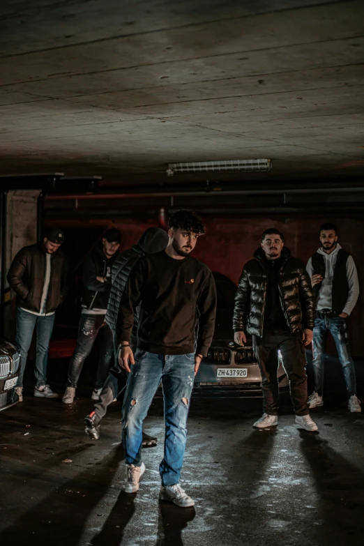 a skateboarder in a garage with several other skaters