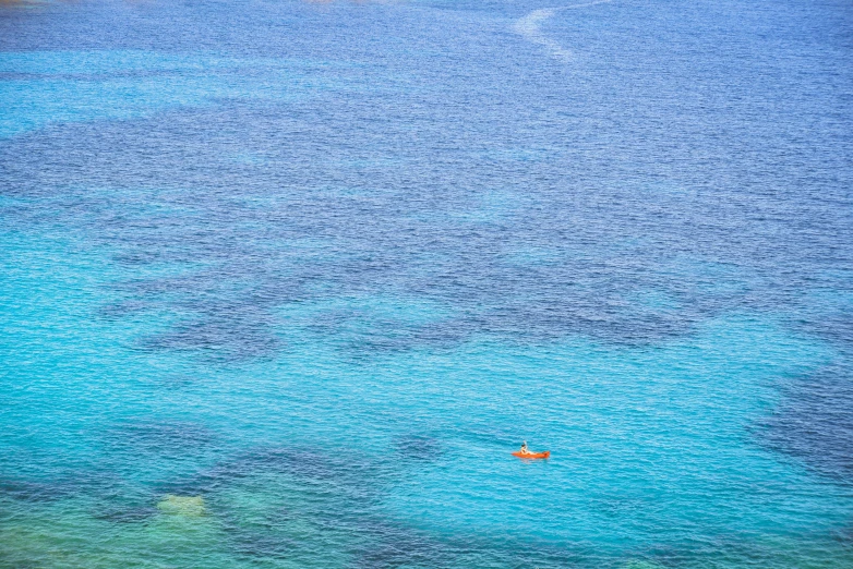 there is an orange boat floating on the water