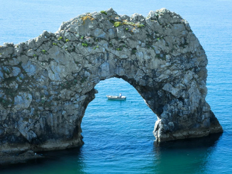 an arch formation on rocks at the shore