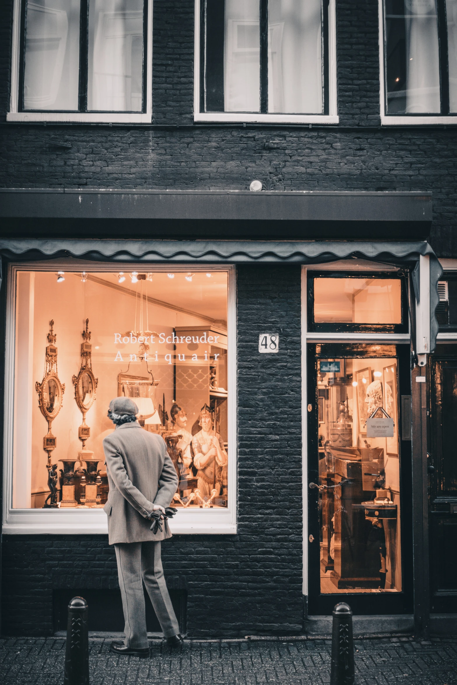 a man in a suit looking out a window