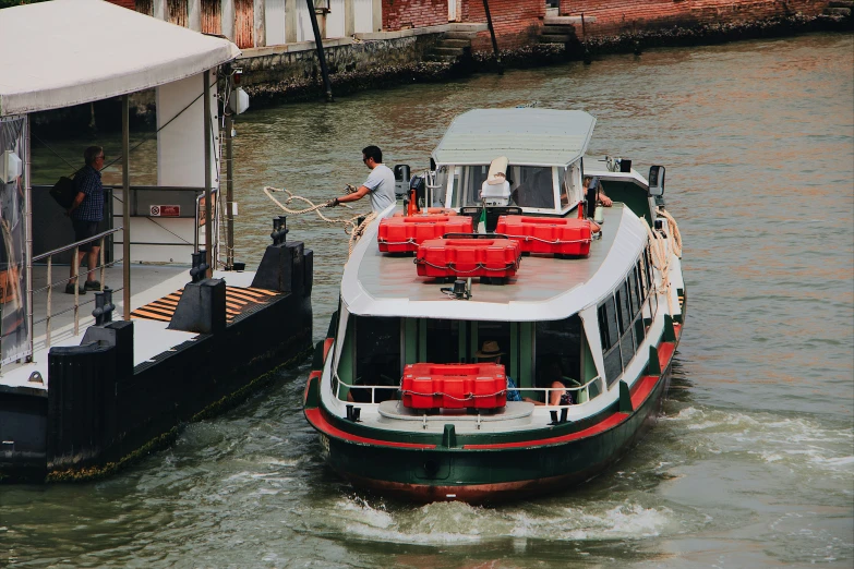 two large ferry boats with red seats are going down the water