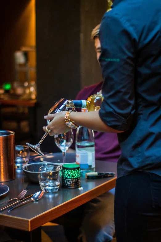 the man is pouring the wine in the glass