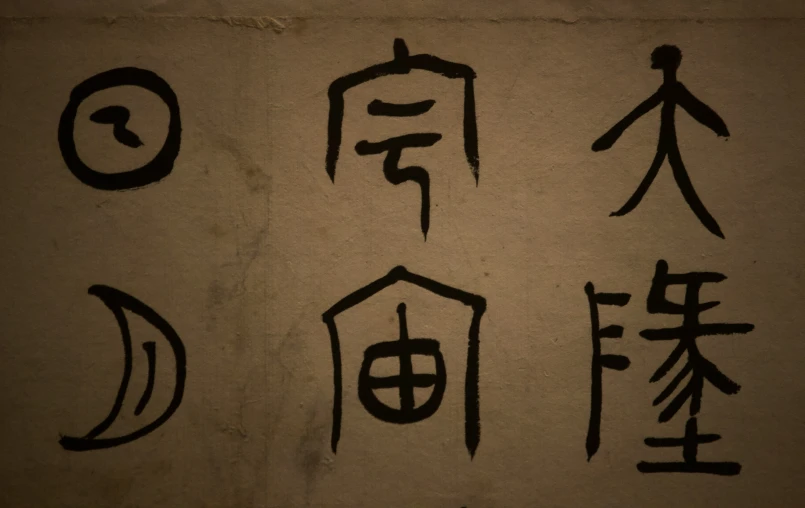 calligraphy on wall depicting asian writing in four languages