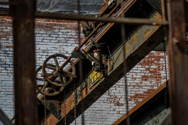 there is a rusted out old machine at the bottom of a large metal beam