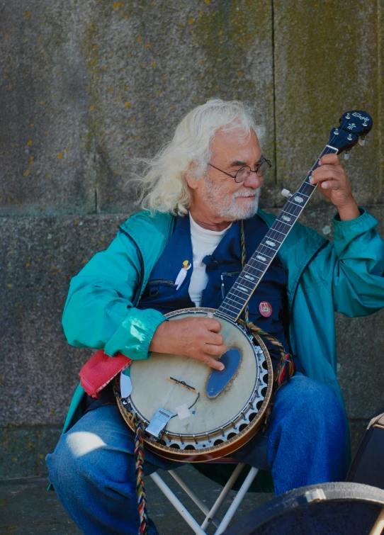 a man sitting and holding an older - fashioned instrument
