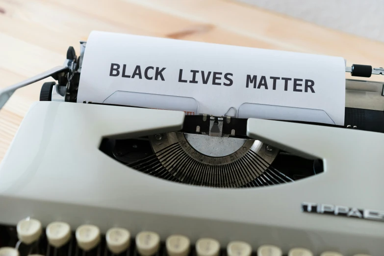 a closeup of an old - fashioned typewriter with a black lives matter written on the paper