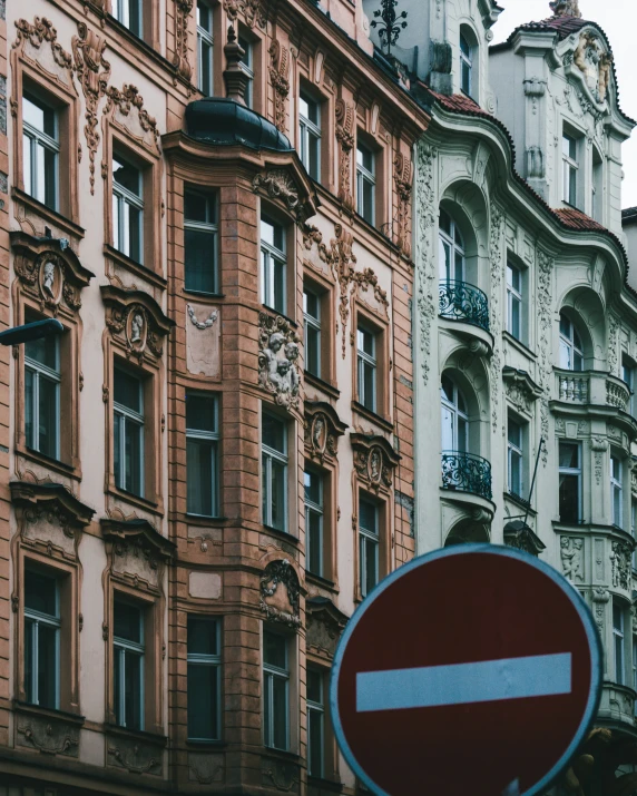 a red and white do not enter sign next to buildings