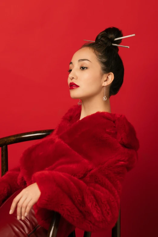 a woman in red fur sitting in a chair