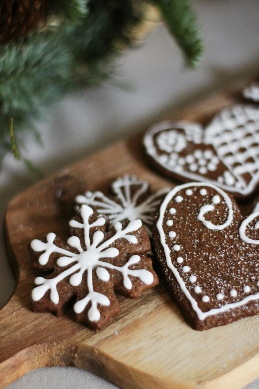 cookies decorated with white decorations are sitting on a wooden board