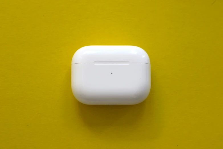 an airpods is resting on a yellow background