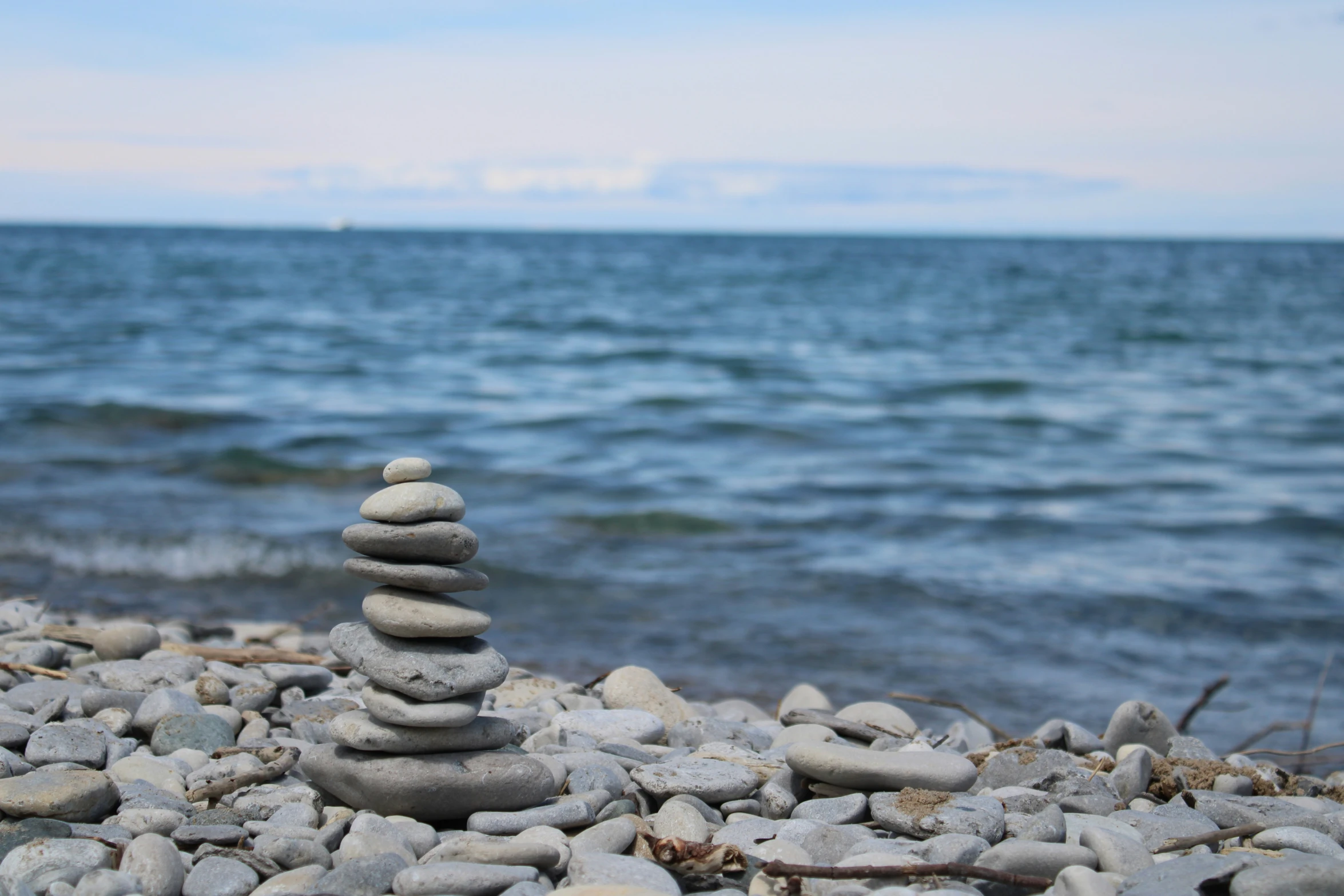 rocks and stones stacked up on the shore near water