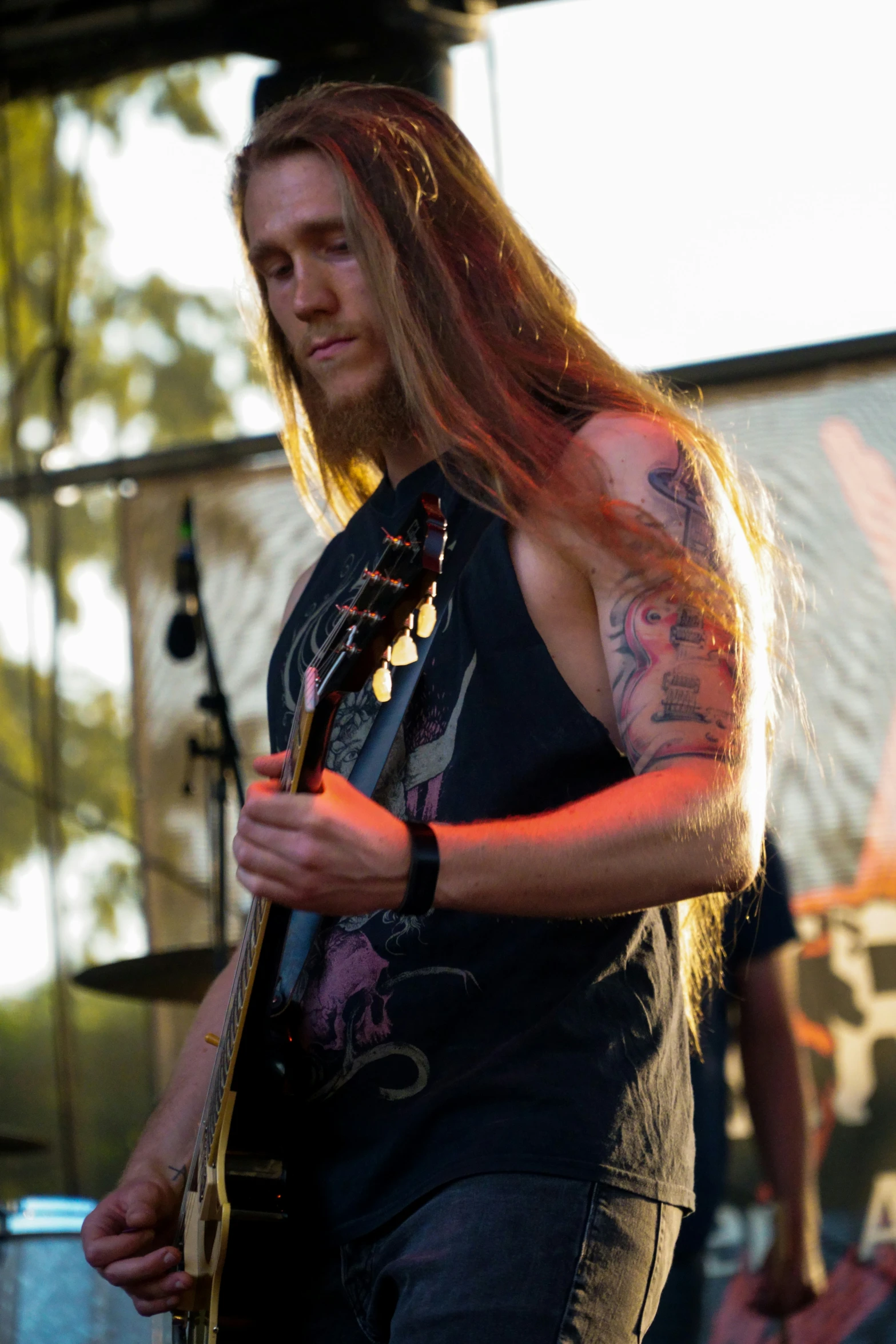 a young man with long hair playing the guitar