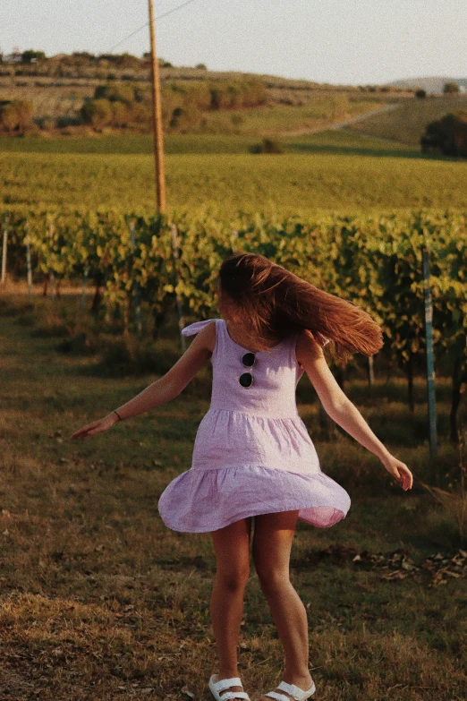  jumping in grass by gvines, wearing pink dress