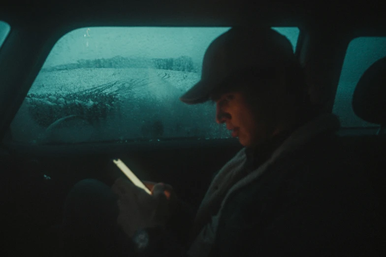 man in dark car with remote, looking at screen