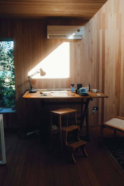 a room with some wooden walls and a desk and window