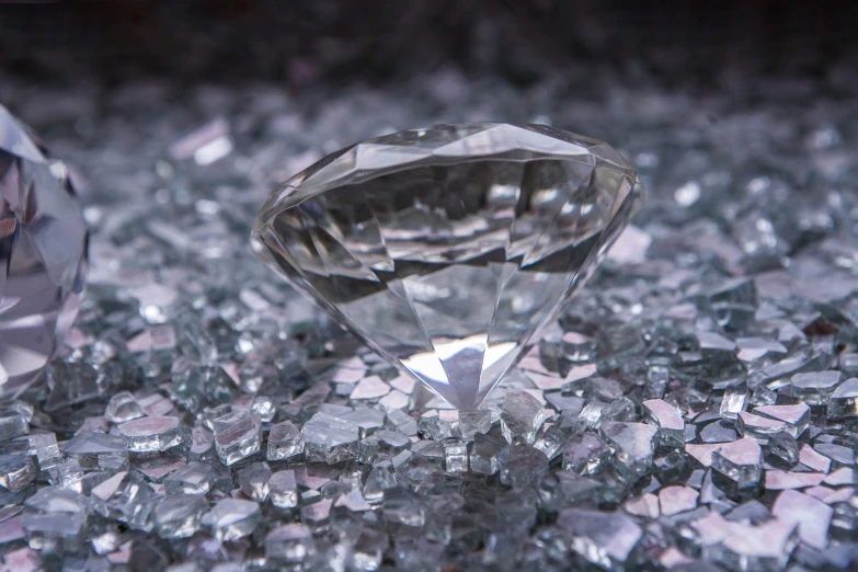 two diamonds sit on top of some crushed glass