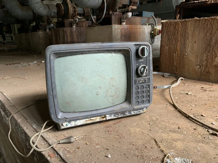 old grey television laying on the ground