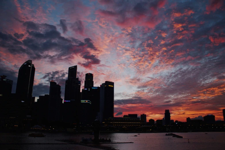 the skyline of a large city lit up with red clouds