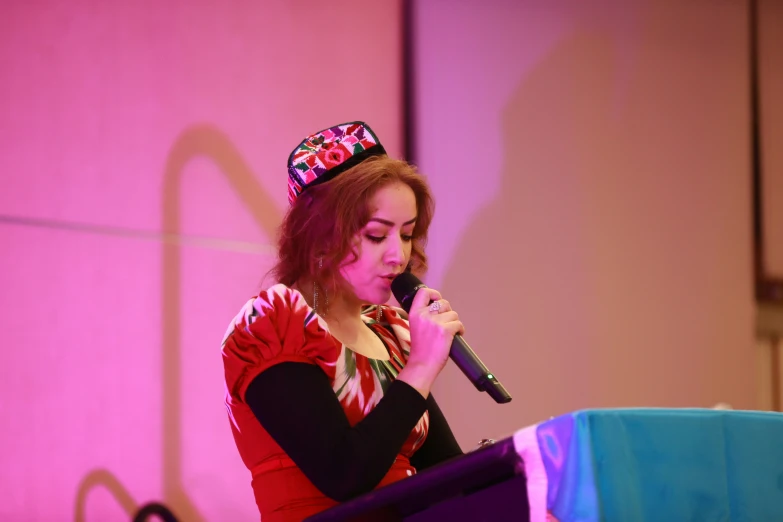 a woman in a crown on top of her head holding a microphone