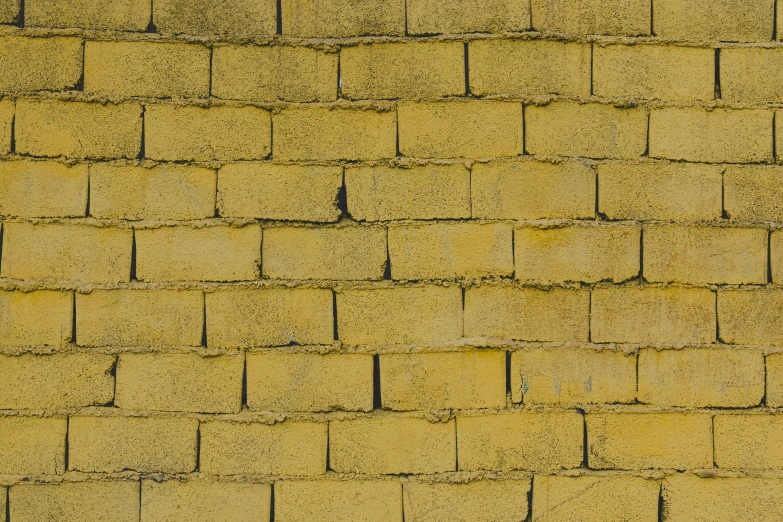 a yellow brick wall has been partially painted