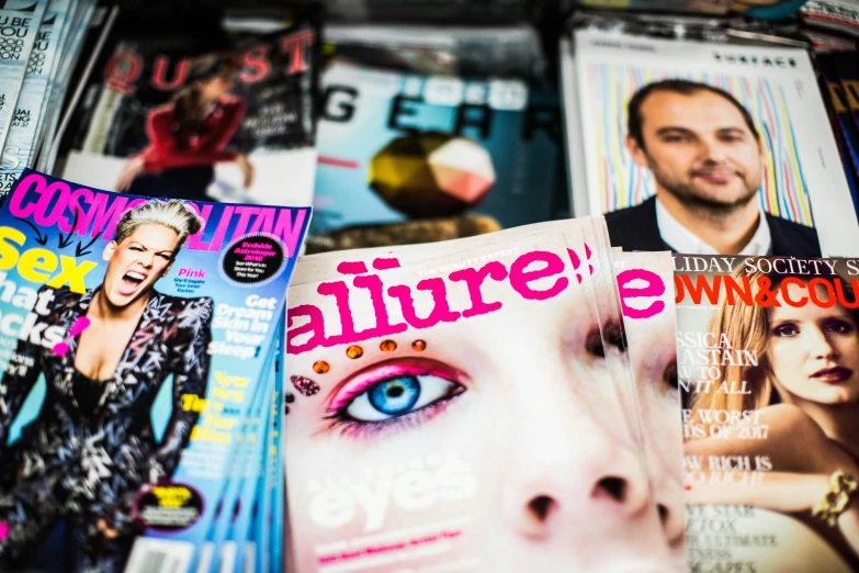 a pile of magazine covers with faces and hair