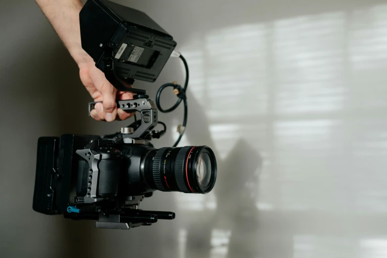 a person holding a camera on top of a tripod