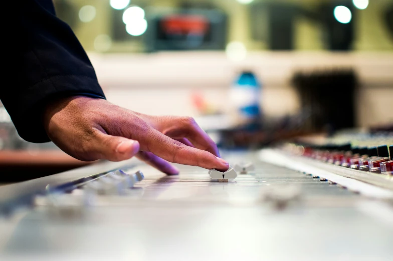 a closeup po of a person touching soing on a sound board