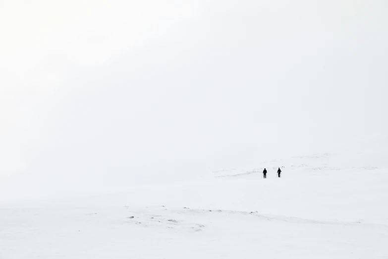 two people standing on a snow covered slope