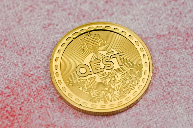 a golden coin with words on it sitting on a pink surface