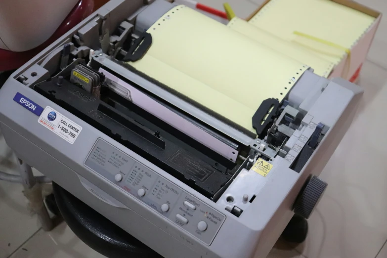 a printer machine and some papers and a red chair