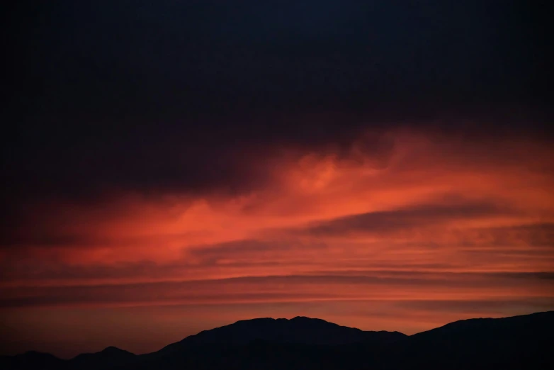a red sky that is over some mountains