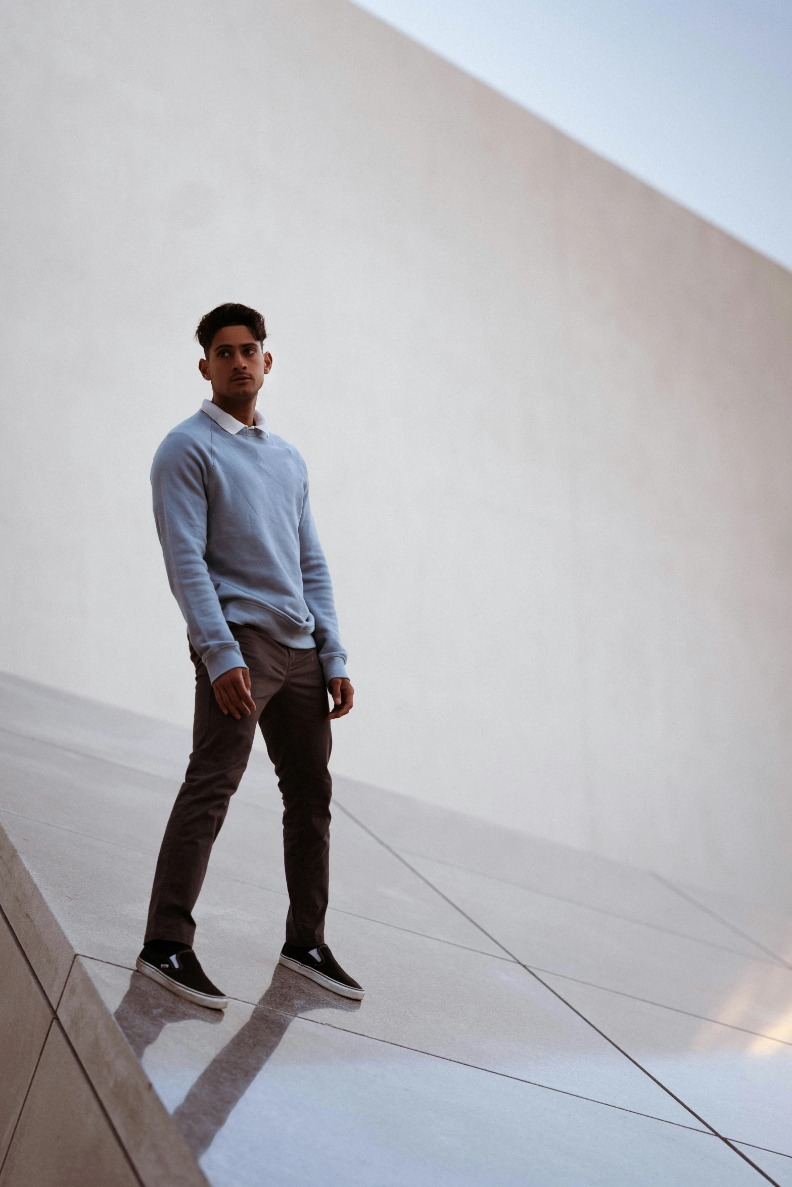 a man standing against a wall with his head down