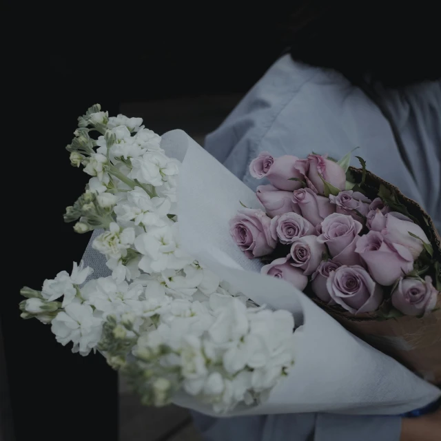 white flowers being carried by someone who is holding them
