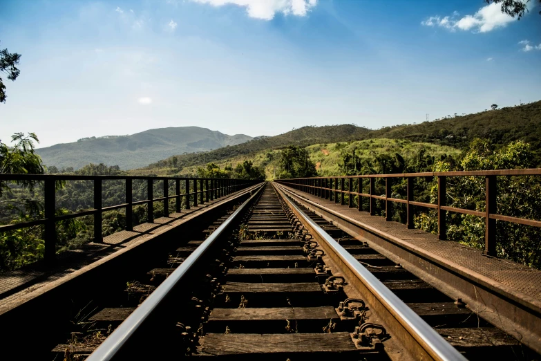 a view from behind train tracks through a forested area